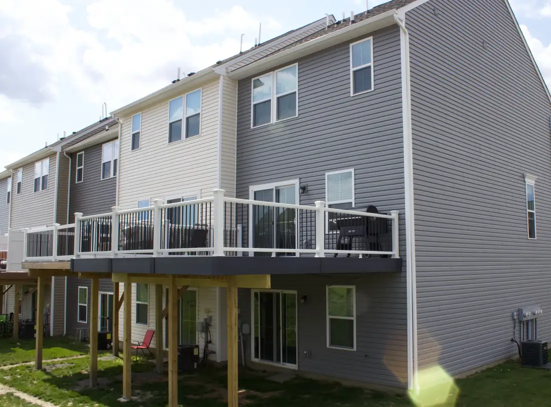 Elevated gray composite deck, white rail — Oasis Custom Decks