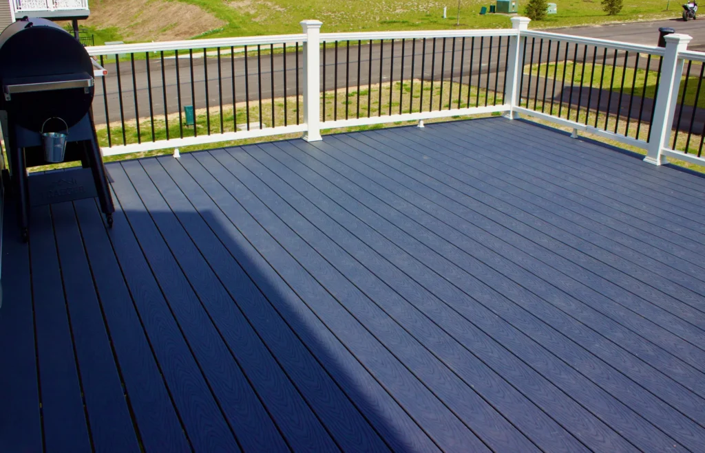 Photo of a deck with dark-colored wooden flooring and a white railing
