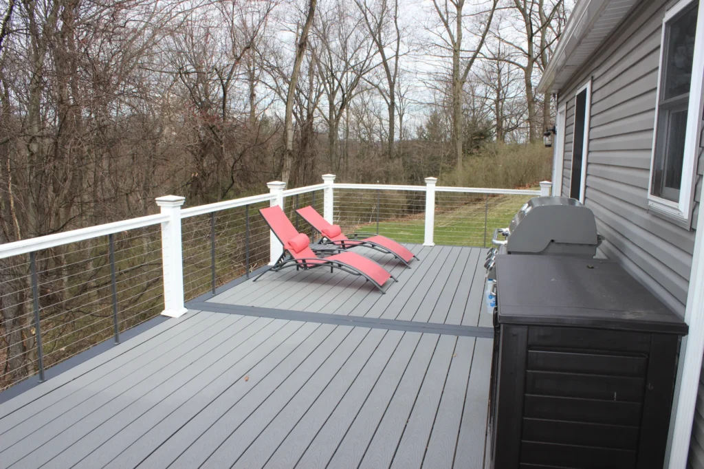 Photo of a raised deck with red chairs and a barbecue