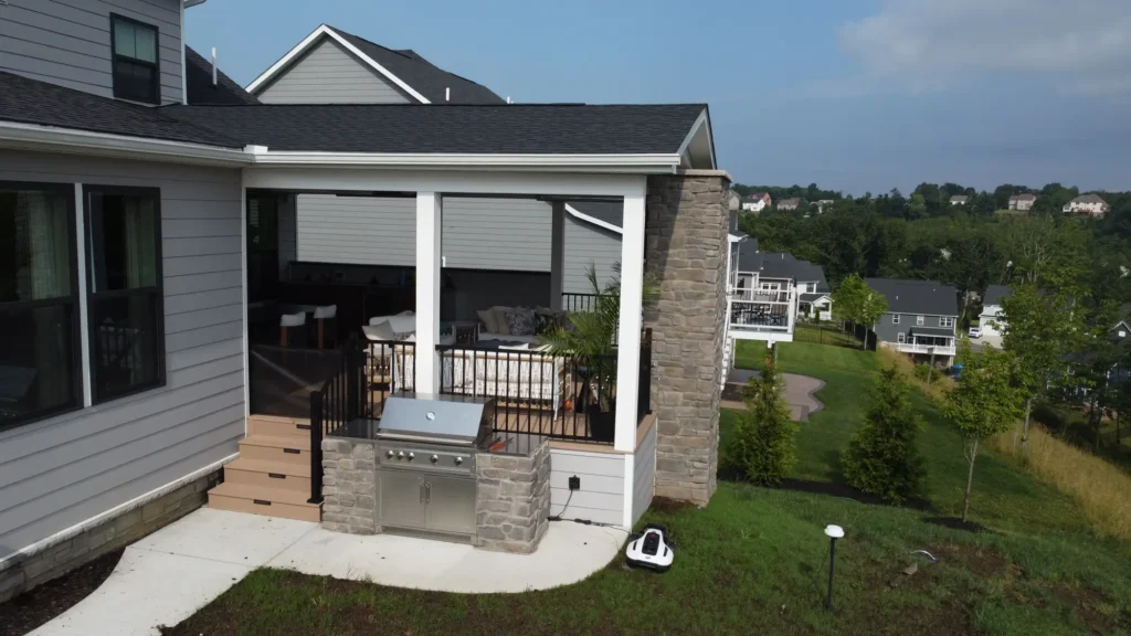 A distant photo of a deck that appears to have a grill on the edge of it