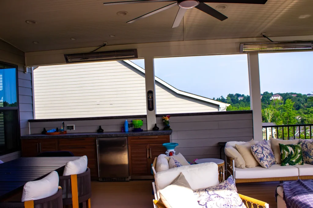 Photo taken inside a deck, showing that it has a handrail, as well as a sofa and a table